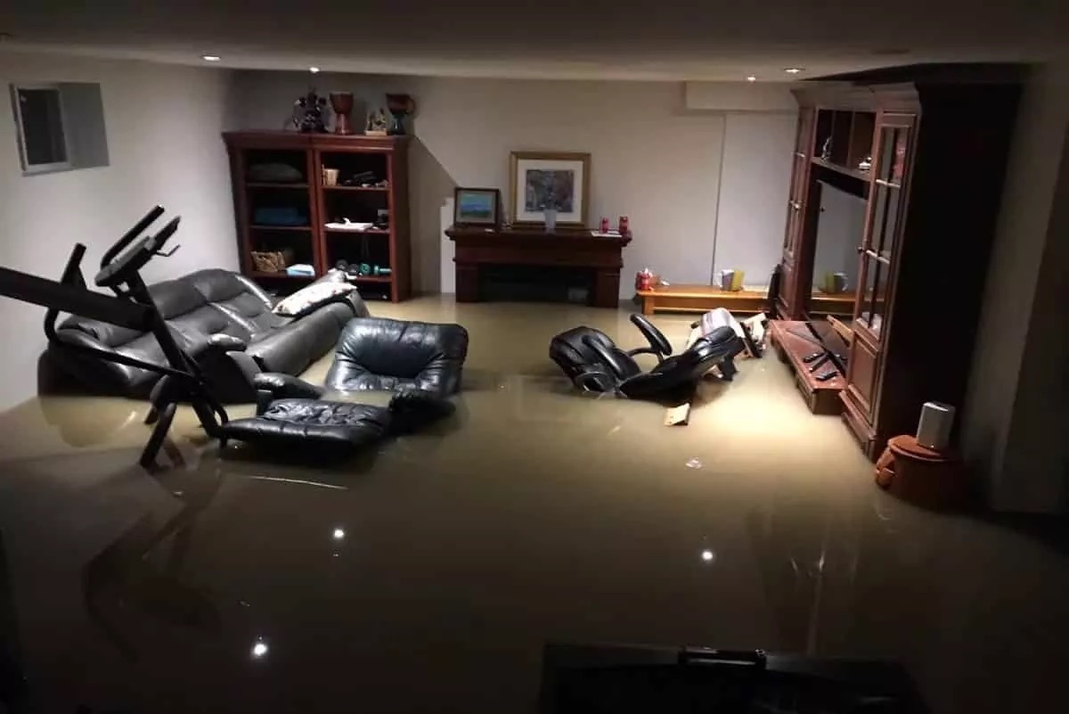 Flooded basement in Connecticut with standing water damaging furniture and finished living space